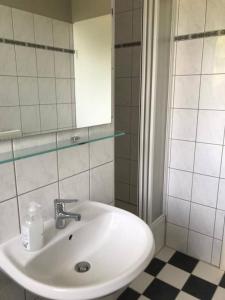 a bathroom with a white sink and a mirror at Annastraße - gemütlich mit schaukeln auf dem Balkon in Magdeburg