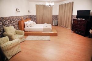 a bedroom with a bed and a chair and a television at O Cabano das Azenhas in Valença