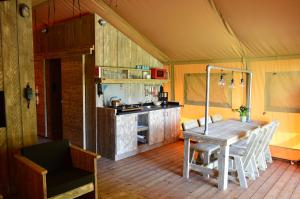 a dining room with a table and a kitchen at Vlugtenburg in s-Gravenzande