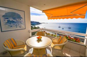 パタラバカにあるPrimera línea Montemarina Anfi del Marの海の景色を望むバルコニー(テーブル、椅子付)