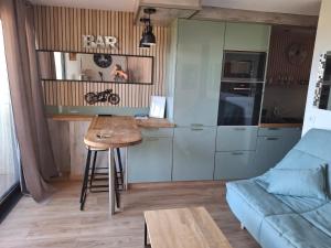 une petite cuisine avec une table et un canapé bleu dans l'établissement TERRA BELLA 2, à Grosseto-Prugna