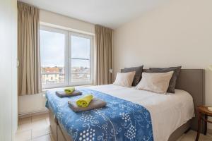 a bedroom with a bed with two pillows and a window at Nori TV in Ostend