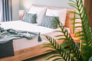 a bedroom with a bed with pillows and a plant at Bloom Garden Apartments in Ierissos