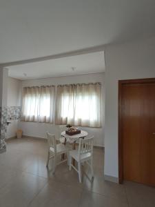 a dining room with a table and two chairs at Recanto das Rosas in Extrema