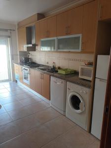 una cocina con lavadora y lavadora en Apartamentos retiro t2, en Nazaré