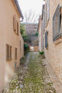 an alley between two buildings with a cobblestone at La Casa di Vina in Fermo +51 photos