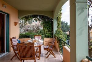 a patio with a table and chairs on a balcony at Barbati Angela's Garden Sea View in Barbati