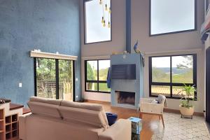 a living room with a couch and a fireplace at Casa, Pequeno Bosque e vista para Horizonte in Ibiúna
