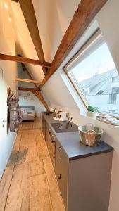 an attic kitchen with a sink and a window at Cosy Authentiek Penthouse in Antwerp +16 photos