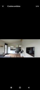 Blick auf eine Küche und ein Wohnzimmer mit einem Tisch in der Unterkunft Le Chalet d'Agen in Boé + 1 Foto