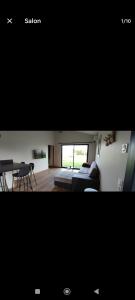 ein Wohnzimmer und ein Wohnzimmer mit einem Sofa und einem Tisch in der Unterkunft Le Chalet d'Agen in Boé