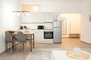 ローバウにあるExklusives City-Apartment am Altmarktのテーブルと冷蔵庫のあるキッチンとダイニングルーム