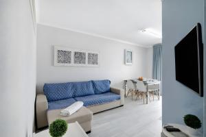 a living room with a blue couch and a table at Seaside Apartment - Praia da Rocha in Portimão