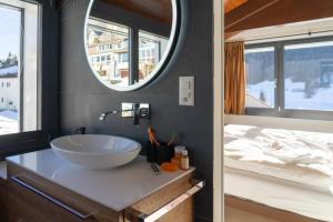 ein Badezimmer mit Waschbecken, Spiegel und Bett in der Unterkunft Alpstern in Wildhaus + 61 Fotos