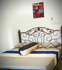 een bed met een metalen hoofdeinde en een schilderij aan de muur bij Classic Spot - Meru Raya in Ipoh