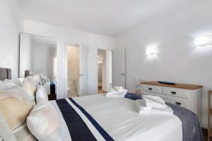 a white bedroom with two beds and a dresser at Seaside Heaven - Praia da Rocha in Portimão +15 photos