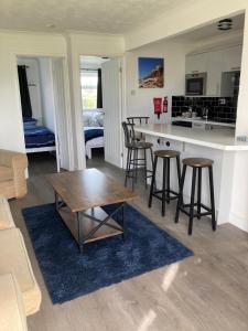 a kitchen and living room with a table and stools at Lorna Doone in Hunstanton