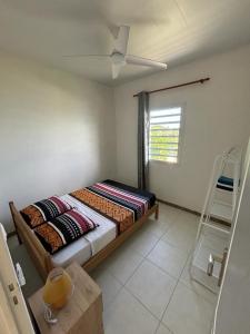 a bedroom with a bed and a ceiling fan at Soleil Levant - Vue mer Imprenable in Le Robert