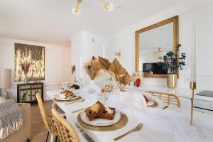 ein Esszimmer mit einem Tisch mit Essen darauf in der Unterkunft Suite de Luxe à 10 min de Paris - Sauna, Cinéma in Bagneux + 32 Fotos