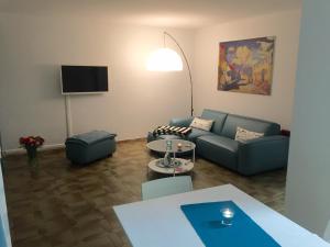 ein Wohnzimmer mit einem Sofa und einem Tisch in der Unterkunft Ferienwohnung Südpark Apartment - Bad Nauheim in Bad Nauheim