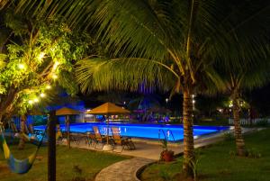 a resort swimming pool at night with palm trees at Laguna Azul Hotel & Suites in Sauce