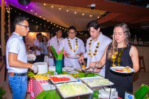 a group of people standing around a table with food at Laguna Azul Hotel & Suites in Sauce