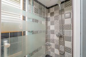 a bathroom with a shower with tiled walls at Superbe Péniche En Centre Ville in Bordeaux