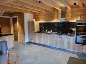 a large kitchen with wooden cabinets and a television at Chalet La Telier in Montriond