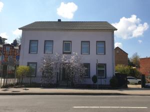 a white house with a black fence on a street at NEU! Appartement Röschen in Burg Stargard