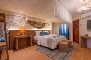 a bedroom with a bed and a stone wall at Dayo Hotel in Flecheiras
