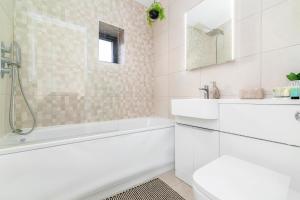 a white bathroom with a tub and a sink at Shoreditch Hoxton London City 3 bed 2 bath over 3 floors Suit Large Families in London