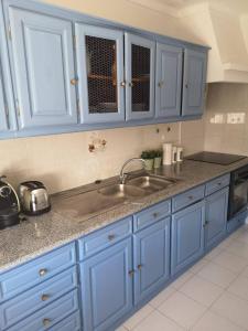 a kitchen with blue cabinets and a sink at Casa da Alzira T2 in Vila Nova de Milfontes +6 photos