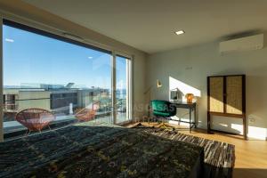 een slaapkamer met een groot raam, een bed en een bureau bij Casa Mango by ACasaDasCasas in Ericeira