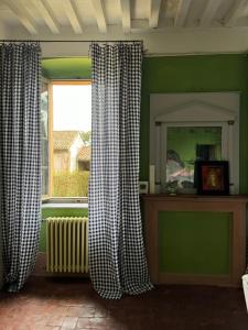 a room with a window with curtains and a radiator at La Colombarola in Pieve Otto Ville