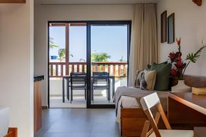 Un dormitorio con una cama y un balcón con una mesa. en Arara house 2, en Jericoacoara