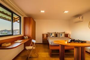 una camera da letto con un letto, un tavolo e una finestra di Arara house 4 a Jericoacoara