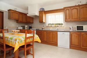 a kitchen with wooden cabinets and a table with a bowl on it at Villa Da Duarte - walkable to beach shops bars in Albufeira