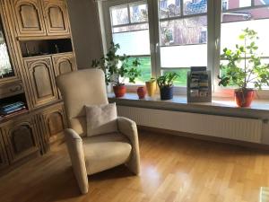 a living room with a chair and a window at Ferienhaus am Emspark in Leer