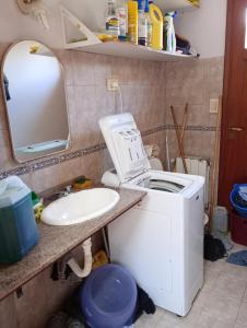 ein Badezimmer mit Waschmaschine und Waschbecken in der Unterkunft CASA RIO TERCERO Cordoba Argentina in Río Tercero