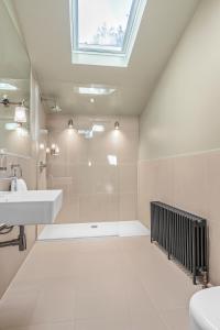 a bathroom with a sink and a shower with a skylight at Clapham Guest House in London +41 photos