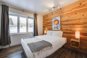 a bedroom with a wooden wall with a bed and a window at Les 3 Vallées - 1911 in Saint-Férréol-les-Neiges +52 photos