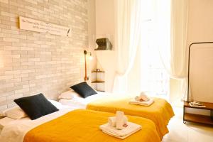 two beds in a room with towels on them at Napoli Cityscape in Naples