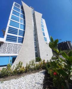 a tall building with some plants in front of it at Aparta suite en Santa Marta in Santa Marta +9 photos