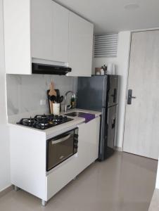 a white kitchen with a stove and a refrigerator at Aparta suite en Santa Marta in Santa Marta