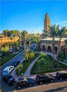 een groep auto's geparkeerd op een straat voor een gebouw bij Riad Jad - Sweet Duplex Appartement in Marrakesh +28 foto's