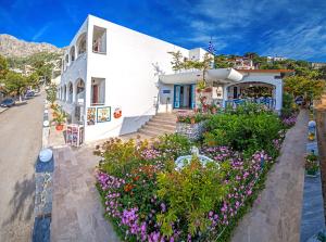 una casa bianca con dei fiori davanti di Nefeli Hotel a Myrties