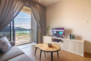 a living room with a couch and a table and a tv at Iconic Regency by Stellar ALV in Bayan Lepas