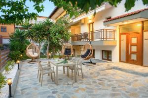 a patio with a table and chairs and a building at Bloom Garden Apartments in Ierissos