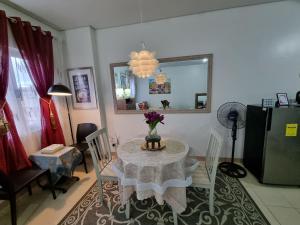a dining room with a table with a vase of flowers on it at Condo for Rent Cheer Residences in Marilao
