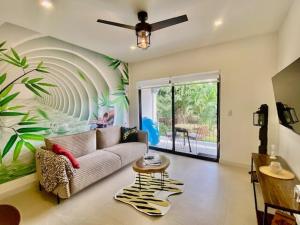 un salon avec un canapé et une fresque murale en palmier dans l'établissement Palmas Resort De Tamarindo Serenity Gem, à Villarreal